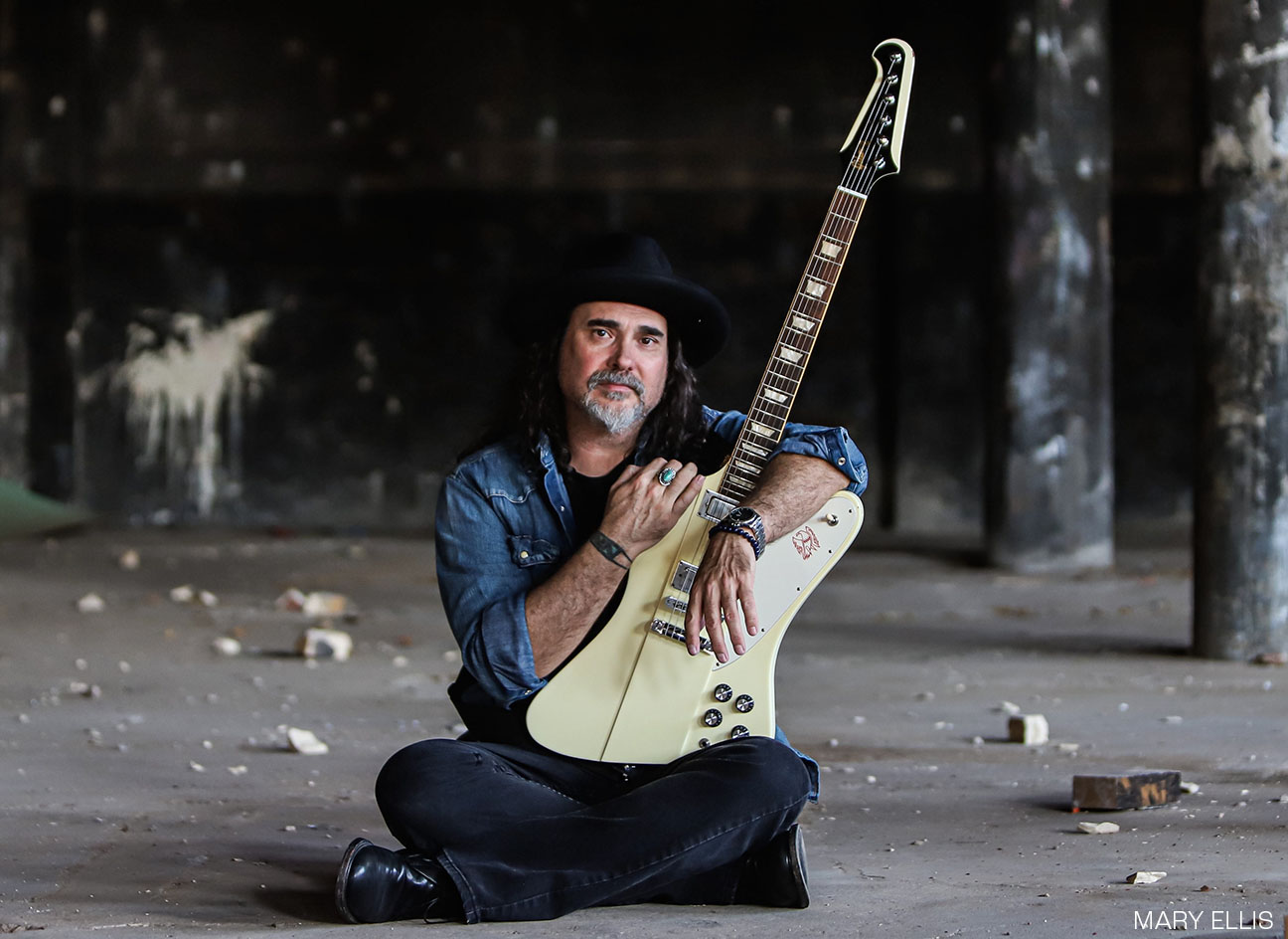 Alastair Greene sitting with guitar, performs at Broadway Oyster Bar